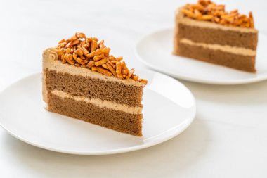 Ev yapımı kahve badem keki beyaz tabakta.