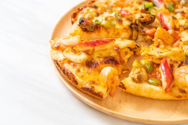 Tahta tepside deniz ürünleri (karides, ahtapot, midye ve yengeç) pizza