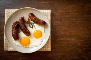 Kahvaltıda omlet ve kızarmış domuz sosisi.