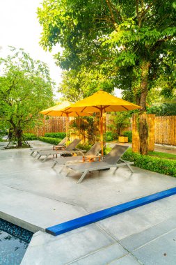 Otelin havuzunda havuz çevresinde şemsiye ve bilardo takımı.