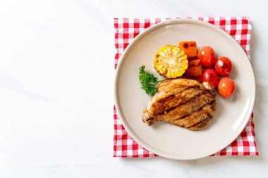 Izgara ve ızgara fileto domuz bifteği, mısır, havuç ve domates.