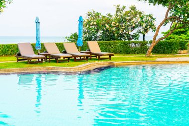 Sandalye havuzu ya da yüzme havuzu etrafında şemsiye olan yatak havuzu