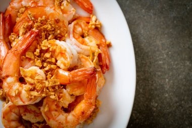 Kızarmış karides ya da beyaz tabakta sarımsaklı karides - deniz ürünleri tarzı.