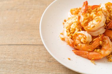 Kızarmış karides ya da beyaz tabakta sarımsaklı karides - deniz ürünleri tarzı.