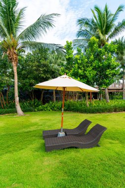 Yüzme havuzunda şemsiyesi olan boş bir plaj sandalyesi