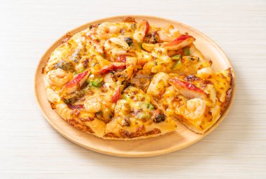 Tahta tepside deniz ürünleri (karides, ahtapot, midye ve yengeç) pizza