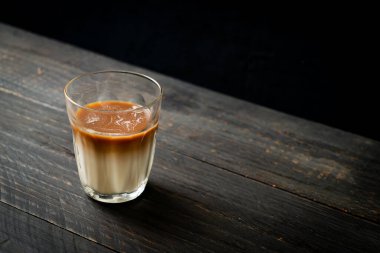 Bir bardak kahve, ahşap arka planda sütlü kahve.