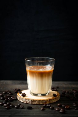 Bir bardak kahve, ahşap arka planda sütlü kahve.