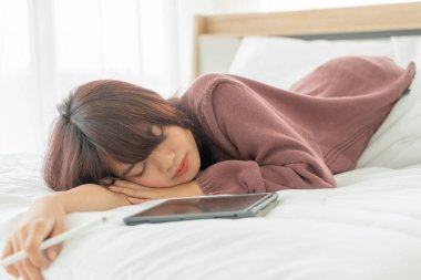 Yatakta tabletle çalışan güzel Asyalı kadınlar