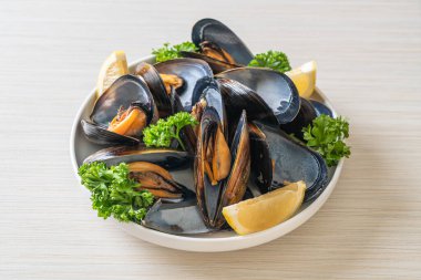 Limonlu bir kasede otlu taze midyeler.