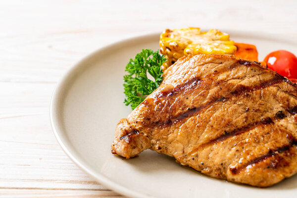 grilled and barbecue fillet pork steak with corn, carrot and tomatoes