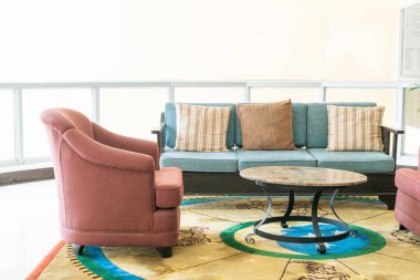 Boş kanepe ve yastıklı sandalye bir odada.