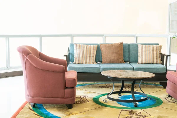 Boş kanepe ve yastıklı sandalye bir odada.