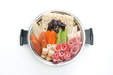 Budae Jjigae ya da Budaejjigae (ordu yahnisi ya da ordu üssü). Kimchi, konserve jambon, sosis, ramen eriştesi ve beyaz arka planda çok daha izole edilmiş.