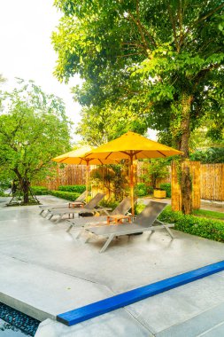 Otelin havuzunda havuz çevresinde şemsiye ve bilardo takımı.