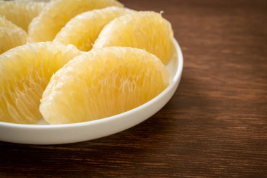 Taze soyulmuş zeytin, greyfurt ya da beyaz tabakta Shaddock.