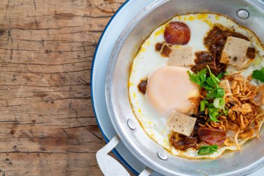 Tavada yumurta ve ahşap arka planda Tayland sosisi.