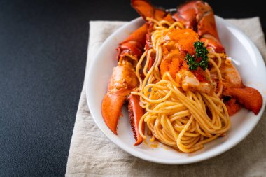 Beyaz tabakta karides yumurtalı ıstakoz spagettisi.