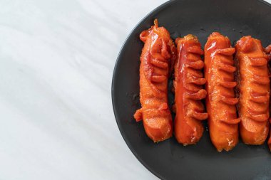 Siyah tabakta kızarmış sosis şişi.