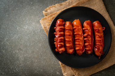 Siyah tabakta kızarmış sosis şişi.