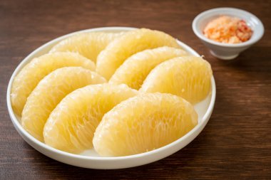 Taze soyulmuş zeytin, greyfurt ya da beyaz tabakta Shaddock.