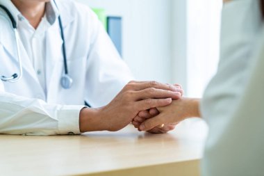 Kıdemli doktor kadın hastasını güven verici el