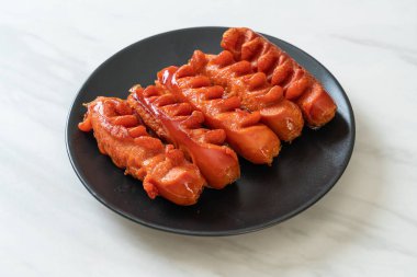 Siyah tabakta kızarmış sosis şişi.