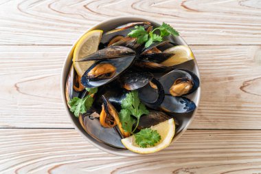 Limonlu bir kasede otlu taze midyeler.
