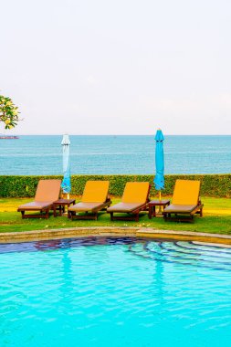 Deniz manzaralı havuz etrafında sandalye havuzu - tatiller ve tatil konsepti