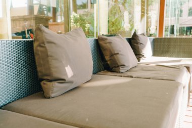 Balkon bölgesindeki kanepede rahat bir yastık dekorasyonu.