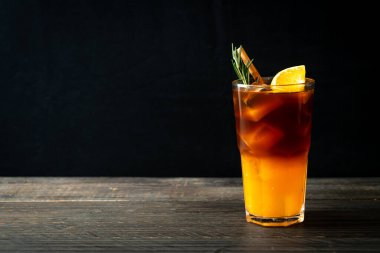 Bir bardak buzlu americano sade kahve ve biberiye ve tarçınla süslenmiş portakal ve limon suyu.