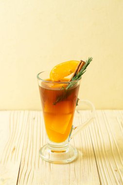 Bir bardak buzlu americano sade kahve ve biberiye ve tarçınla süslenmiş portakal ve limon suyu.