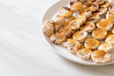 Izgarada dilimlenmiş muz ve karamel sosu.