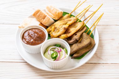 Pork Satay ve Ciğer Satay. Ekmek, fıstık sosu ve turşu. Salatalık dilimleri ve soğan sirkeli.