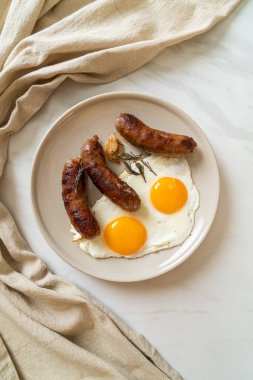 Kahvaltıda omlet ve kızarmış domuz sosisi.