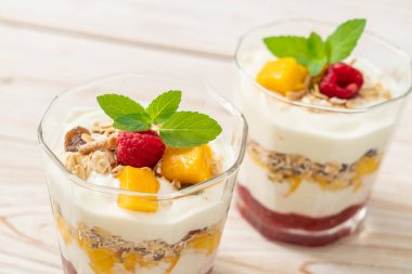 Ev yapımı taze mango ve yoğurt ve granola ile taze ahududu. Sağlıklı yemek tarzı.