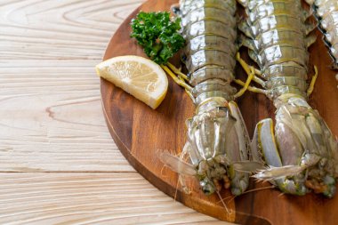 Tahtada limon olan taze peygamber devesi karidesi.