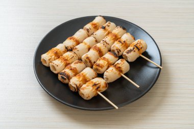 Izgara tüp şeklinde balık ezmeli kek ya da tabakta mürekkep balığı şişi.