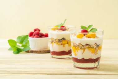 Ev yapımı taze mango ve yoğurt ve granola ile taze ahududu. Sağlıklı yemek tarzı.