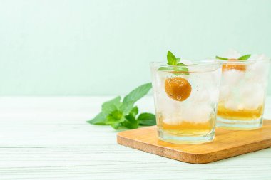 Sodayla buzlu erik suyu ve ahşap masada nane şekeri - içecek.