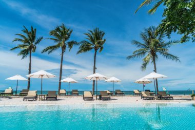 Plaj geçmişine sahip otel havuzunda yüzme havuzu etrafında plaj sandalyesi - tatil ve tatil kavramı