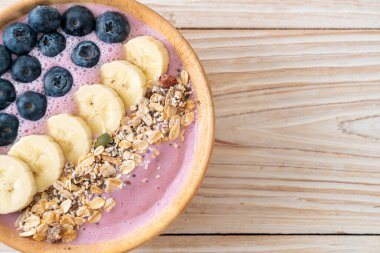 Yoğurt ya da yoğurtlu smoothie kasesi, böğürtlen, muz ve granola.