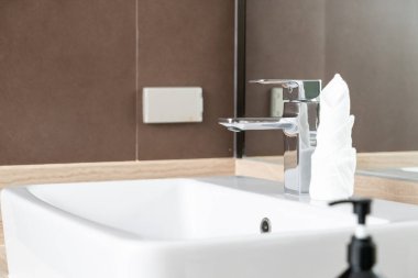 Modern metalik musluğun banyodaki yakın çekimi.