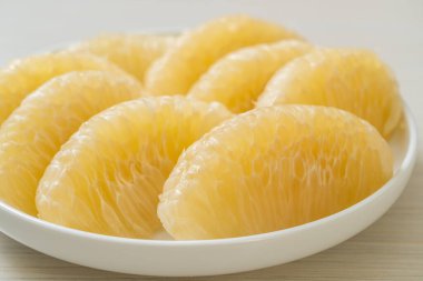 Taze soyulmuş zeytin, greyfurt ya da beyaz tabakta Shaddock.