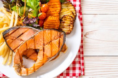 Çift ızgara somon bifteği, sebze ve patates kızartması.