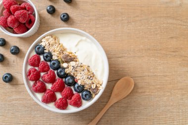 Ev yapımı yoğurt kasesi, ahududu, yaban mersini ve granola. Sağlıklı yemek tarzı.