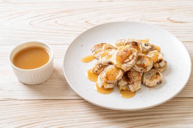 Izgarada dilimlenmiş muz ve karamel sosu.