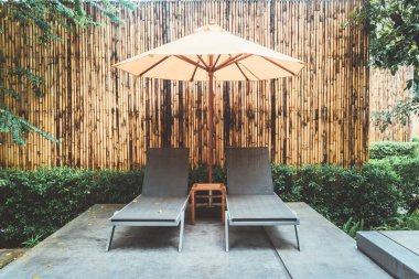 Otelin havuzunda havuz çevresinde şemsiye ve bilardo takımı.