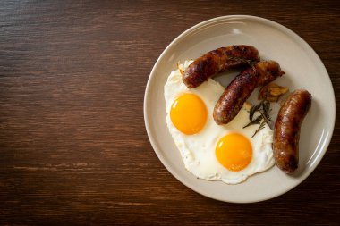 Kahvaltıda omlet ve kızarmış domuz sosisi.