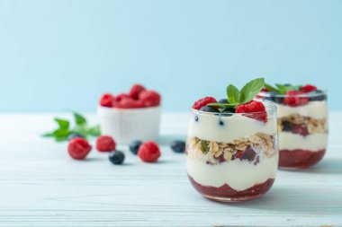 Ev yapımı ahududu ve yaban mersinli yoğurt ve granola. Sağlıklı yemek tarzı.